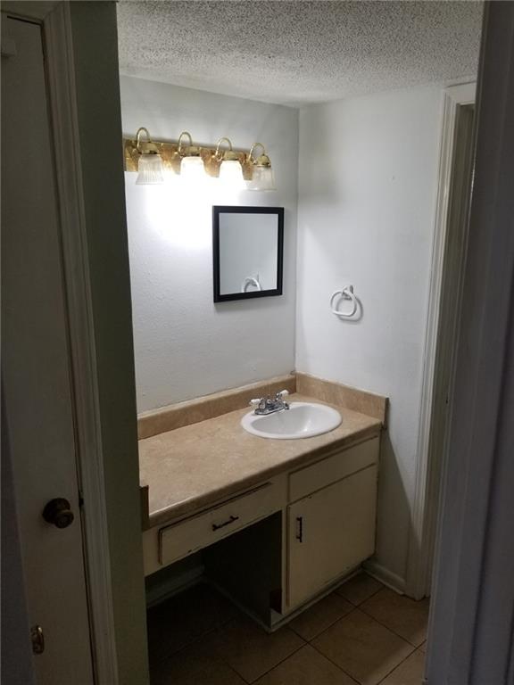 6220 Riverside Dr Unit 556, Metairie, LA 70003 - bathroom featuring vanity, a textured ceiling, and tile patterned floors
