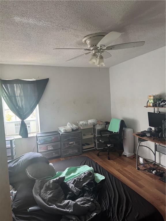 6220 Riverside Dr Unit 556, Metairie, LA 70003 - bedroom featuring a textured ceiling, wood finished floors, and a ceiling fan