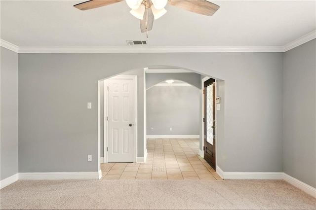 1900 Woods Dr, Metairie, LA 70001 - tiled empty room with carpet floors, crown molding, arched walkways, ceiling fan, and baseboards