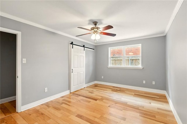 1900 Woods Dr, Metairie, LA 70001 - unfurnished bedroom with a barn door, light wood finished floors, baseboards, ornamental molding, and a ceiling fan