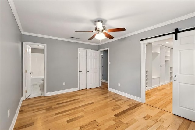 1900 Woods Dr, Metairie, LA 70001 - unfurnished bedroom with light wood-style flooring, baseboards, ornamental molding, ensuite bathroom, and a closet