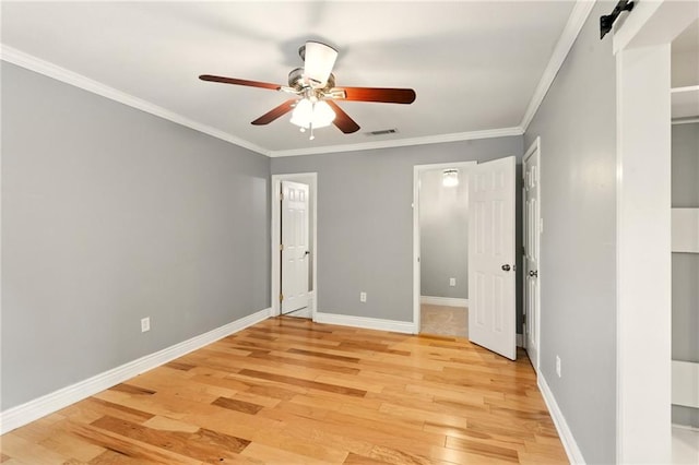 1900 Woods Dr, Metairie, LA 70001 - unfurnished bedroom featuring light wood-style floors, ornamental molding, baseboards, a ceiling fan, and a barn door