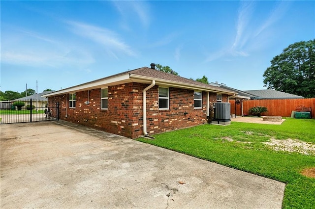 1900 Woods Dr, Metairie, LA 70001 - back of property with central AC, concrete driveway, brick siding, and a gate