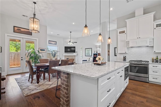 421 Tiger Ave, Covington, LA 70433 - kitchen with stainless steel appliances, ventilation hood, a kitchen island, ceiling fan, and white cabinetry