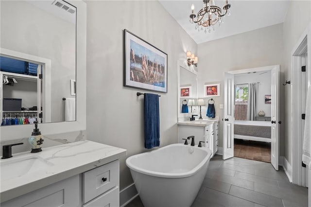 421 Tiger Ave, Covington, LA 70433 - full bath featuring ensuite bathroom, vanity, a soaking tub, a chandelier, and baseboards