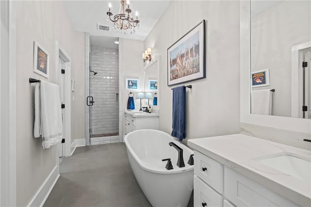 421 Tiger Ave, Covington, LA 70433 - bathroom with two vanities, a shower stall, a chandelier, a freestanding tub, and tile patterned flooring