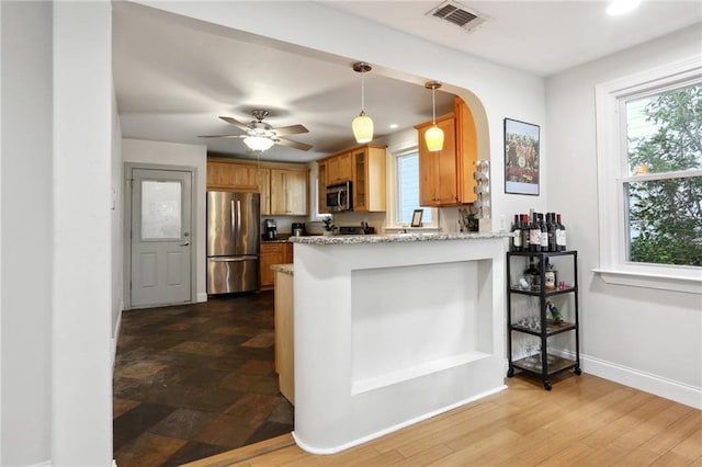 6550 General Diaz St, New Orleans, LA 70124 - kitchen with appliances with stainless steel finishes, a peninsula, brown cabinets, baseboards, and arched walkways