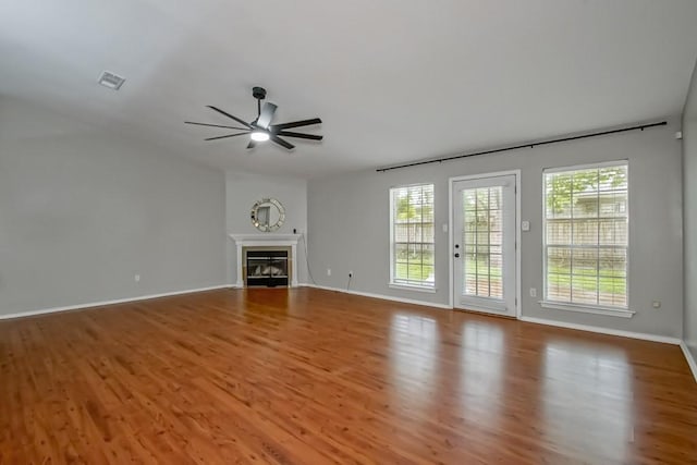 1550 De Battista Pl, New Orleans, LA 70131 - unfurnished living room featuring a ceiling fan, wood finished floors, baseboards, and a glass covered fireplace
