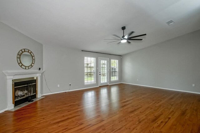 1550 De Battista Pl, New Orleans, LA 70131 - unfurnished living room featuring ceiling fan, wood finished floors, baseboards, a fireplace with flush hearth, and lofted ceiling