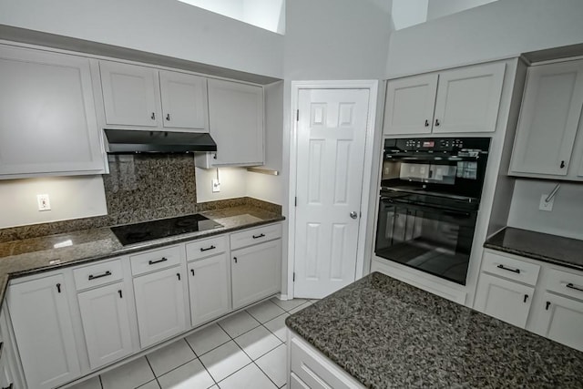 1550 De Battista Pl, New Orleans, LA 70131 - kitchen with under cabinet range hood, black appliances, dark stone countertops, light tile patterned floors, and backsplash