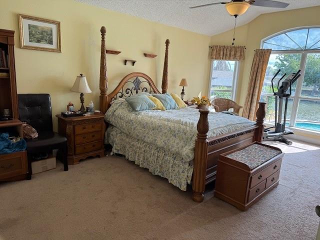 203 Lorelei Cir, Slidell, LA 70458 - bedroom with light colored carpet, multiple windows, vaulted ceiling, access to outside, and a textured ceiling