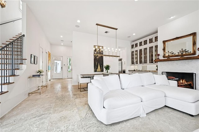 2538 N Rampart St, New Orleans, LA 70117 - living area featuring stairs, recessed lighting, a chandelier, and a lit fireplace