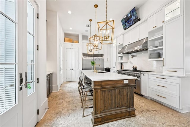 2538 N Rampart St, New Orleans, LA 70117 - kitchen featuring appliances with stainless steel finishes, under cabinet range hood, a chandelier, light countertops, and white cabinets
