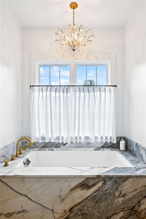 2538 N Rampart St, New Orleans, LA 70117 - full bath featuring a bath and a chandelier