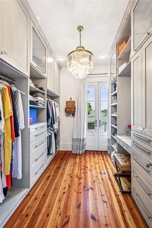 2538 N Rampart St, New Orleans, LA 70117 - walk in closet with light wood-style flooring, a chandelier, and french doors