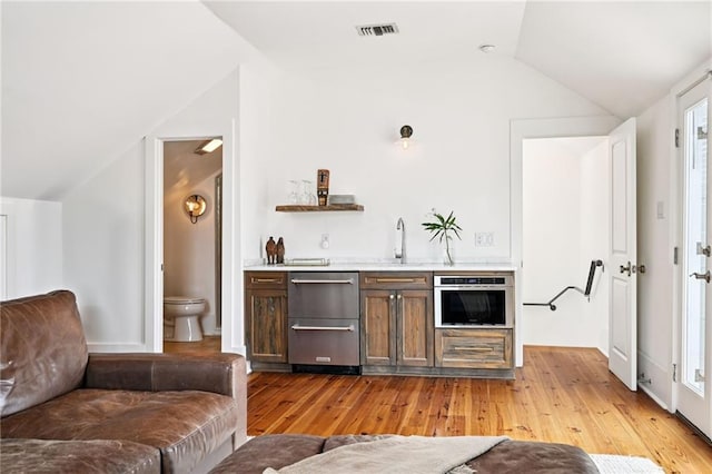 2538 N Rampart St, New Orleans, LA 70117 - indoor wet bar with lofted ceiling, stainless steel appliances, and light wood-style flooring