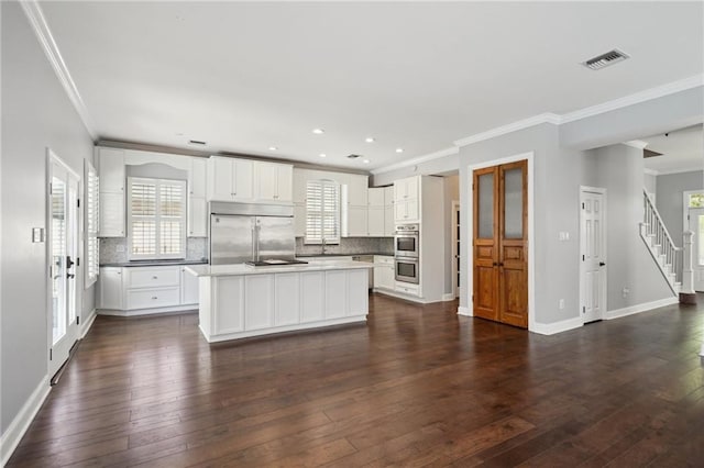 5830 Marshal Foch St, New Orleans, LA 70124 - kitchen featuring stainless steel appliances, crown molding, tasteful backsplash, dark wood-type flooring, and baseboards