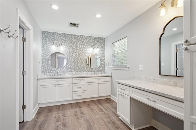 5830 Marshal Foch St, New Orleans, LA 70124 - bathroom featuring double vanity, wood finished floors, backsplash, and recessed lighting