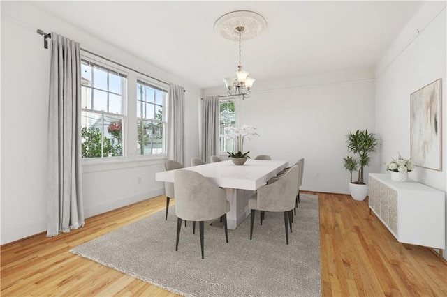 5524 S Galvez St, New Orleans, LA 70125 - dining area featuring a chandelier, light wood-style flooring, and baseboards