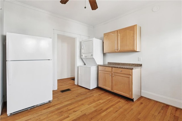 5524 S Galvez St, New Orleans, LA 70125 - washroom with stacked washing machine and dryer, ornamental molding, light wood-type flooring, ceiling fan, and baseboards