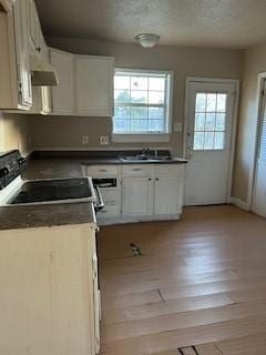 8830 Stroelitz St, New Orleans, LA 70118 - kitchen featuring wall chimney exhaust hood, dark countertops, a sink, a textured ceiling, and range with electric cooktop