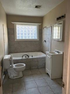 8830 Stroelitz St, New Orleans, LA 70118 - full bathroom featuring tile patterned flooring, vanity, toilet, a bidet, and a textured ceiling