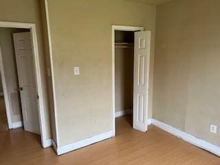 8830 Stroelitz St, New Orleans, LA 70118 - unfurnished bedroom with light wood-style flooring, baseboards, and a closet