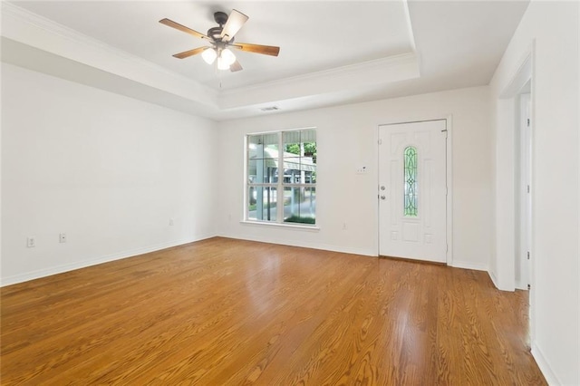 1105 Forest Ln, Mandeville, LA 70448 - foyer entrance with a tray ceiling, wood finished floors, crown molding, a ceiling fan, and baseboards