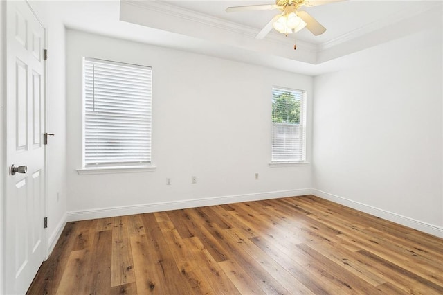 1105 Forest Ln, Mandeville, LA 70448 - spare room featuring ornamental molding, wood-type flooring, a tray ceiling, a ceiling fan, and baseboards