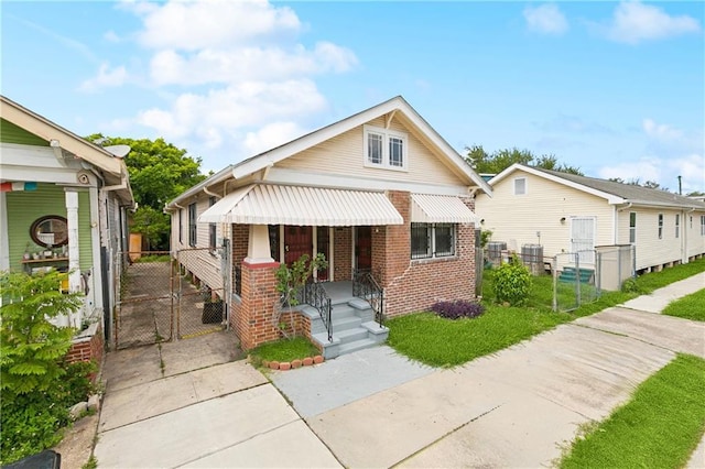 3717 S Johnson St, New Orleans, LA 70125 - view of front of home with a gate, brick siding, a porch, and central AC unit