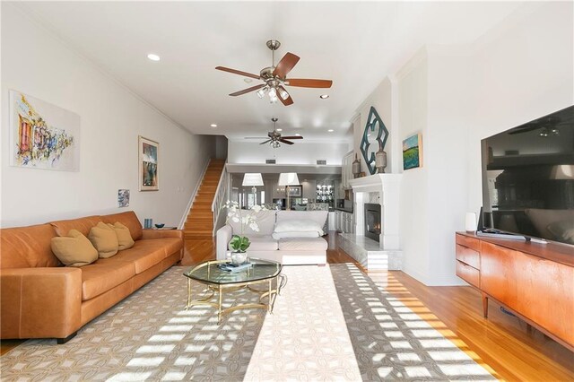 7300 Lakeshore Dr Unit 4, New Orleans, LA 70124 - living room with a ceiling fan, wood finished floors, stairway, ornamental molding, and a glass covered fireplace