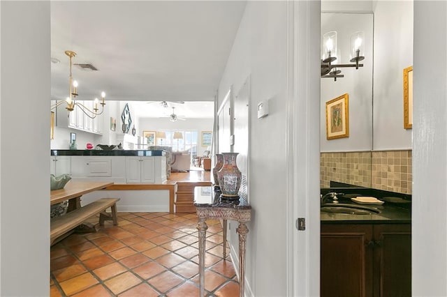 7300 Lakeshore Dr Unit 4, New Orleans, LA 70124 - kitchen with dark countertops, white cabinetry, backsplash, and light tile patterned floors