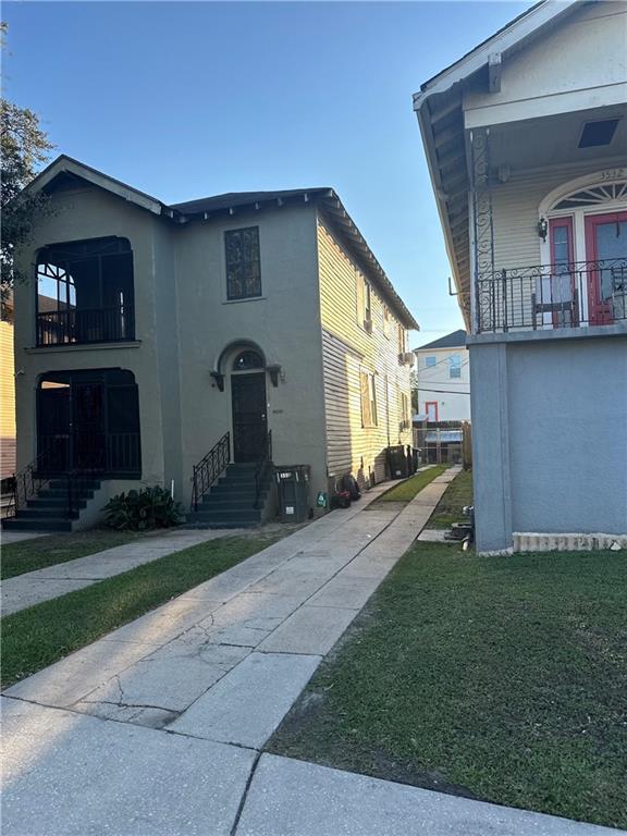 3526 Louisiana Ave Parkway, New Orleans, LA 70125 - view of front of house featuring a balcony, entry steps, driveway, and stucco siding