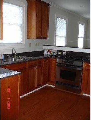 360 Vinet Ave, Jefferson, LA 70121 - kitchen with gas range oven, brown cabinets, dark wood-type flooring, and ornamental molding