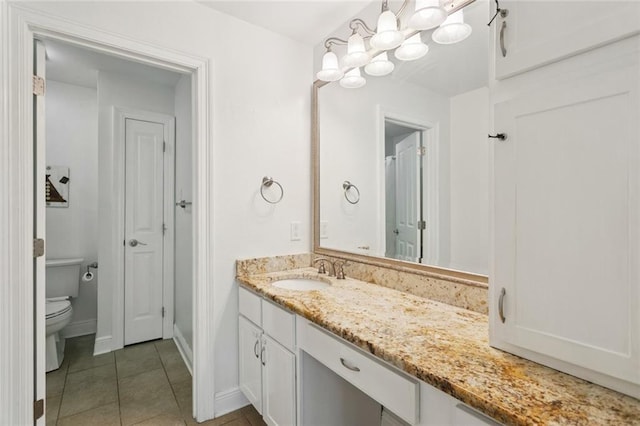 103 Catalpa Ln Unit 231, Mandeville, LA 70471 - bathroom with toilet, vanity, tile patterned flooring, baseboards, and a chandelier