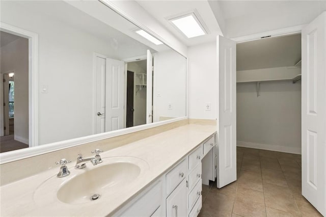 103 Catalpa Ln Unit 231, Mandeville, LA 70471 - bathroom with vanity, a spacious closet, tile patterned floors, and baseboards