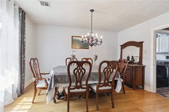 41 Yellowstone Dr, New Orleans, LA 70131 - dining room featuring washer / dryer, light wood finished floors, a chandelier, and baseboards