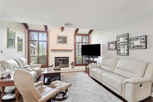 585 Beau Chene Dr, Mandeville, LA 70471 - living room featuring a textured ceiling, healthy amount of natural light, and a fireplace