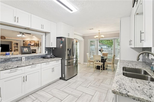 2018 Old River Rd, Slidell, LA 70461 - kitchen with stainless steel refrigerator with ice dispenser, a sink, crown molding, white cabinetry, and a chandelier