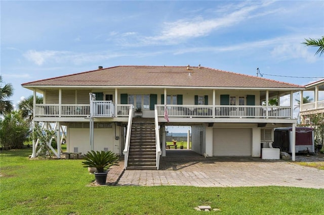 329 Carr Dr, Slidell, LA 70458 - back of house featuring an attached garage, stairway, a lawn, driveway, and a porch