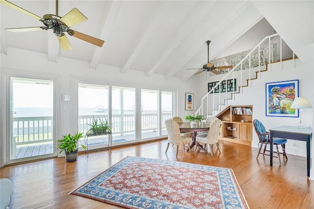 329 Carr Dr, Slidell, LA 70458 - dining space featuring ceiling fan, stairway, beamed ceiling, wood finished floors, and high vaulted ceiling