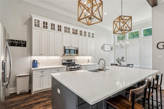 668 Highlands Dr, Slidell, LA 70458 - kitchen featuring appliances with stainless steel finishes, a sink, a chandelier, dark wood-type flooring, and crown molding