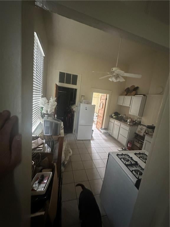 70911 Evelina St, New Orleans, LA 70114 - kitchen featuring white appliances, a ceiling fan, white cabinets, light tile patterned flooring, and a sink