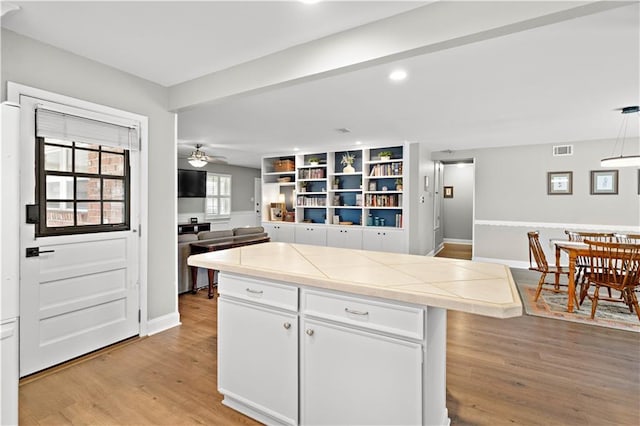 1924 Cammie Ave, Metairie, LA 70003 - kitchen with tile counters, light wood finished floors, white cabinetry, ceiling fan, and recessed lighting