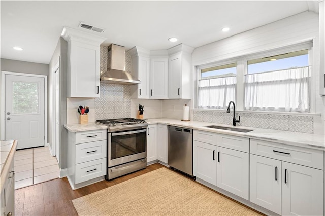 1924 Cammie Ave, Metairie, LA 70003 - kitchen featuring stainless steel appliances, a sink, wall chimney exhaust hood, healthy amount of natural light, and recessed lighting