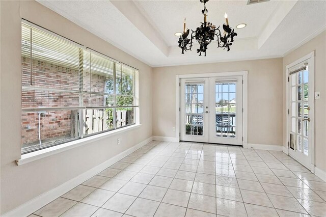 118 Weatherly Cv, Slidell, LA 70458 - unfurnished room featuring french doors, a tray ceiling, a chandelier, light tile patterned flooring, and baseboards