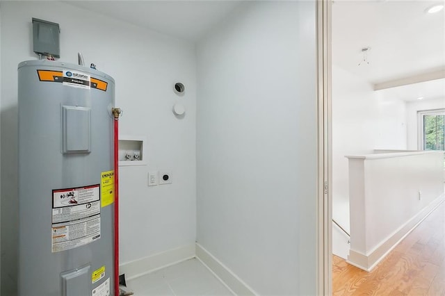822 N Rampart St Unit 301, New Orleans, LA 70116 - laundry area with water heater, hookup for a washing machine, electric dryer hookup, light wood finished floors, and baseboards