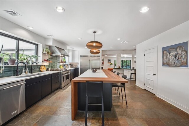 788 Amethyst St, New Orleans, LA 70124 - kitchen with premium appliances, butcher block counters, stone tile floors, a sink, and recessed lighting