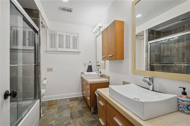 788 Amethyst St, New Orleans, LA 70124 - bathroom with two vanities, stone finish floors, baseboards, and toilet