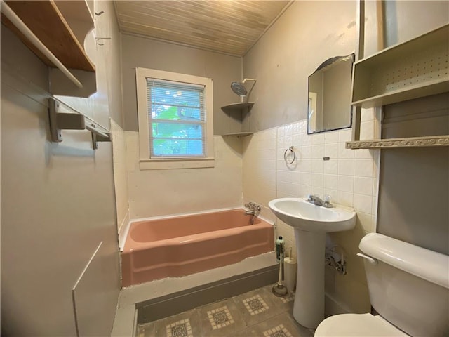 63070 Oak St, Roseland, LA 70456 - bathroom featuring toilet, tile walls,  shower combination, backsplash, and a sink